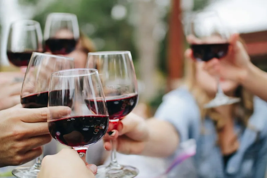 Brindis con copas de vino alrededor de una mesa